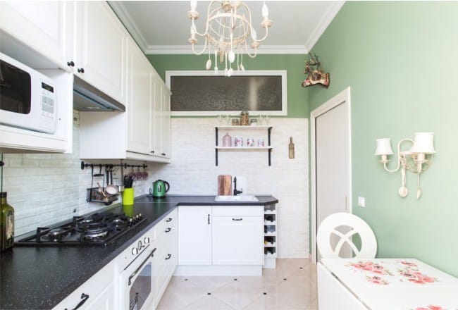 The interior of a small kitchen with a window in the wall