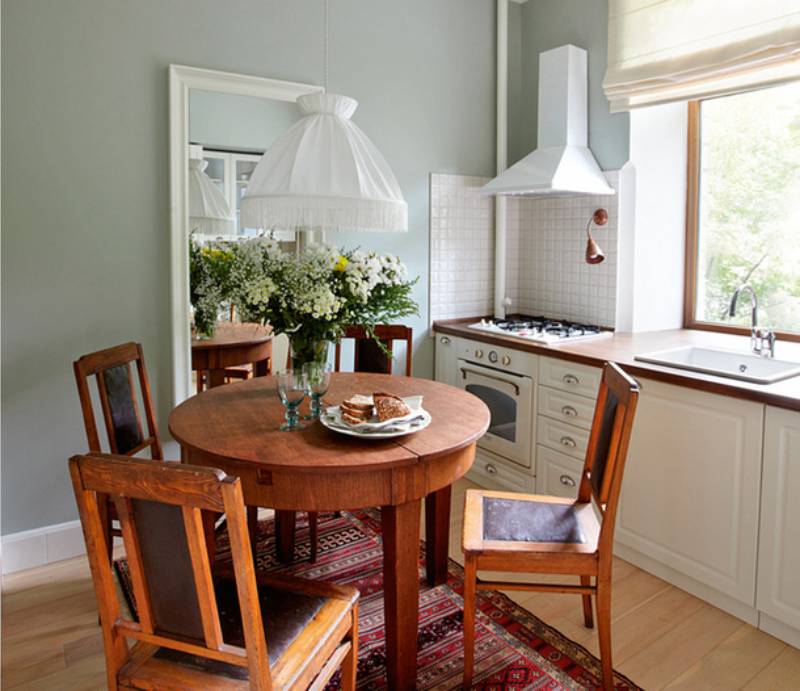 Round small wooden table in the interior of a small kitchen