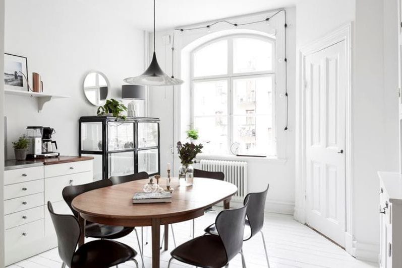 Oval wooden table in the interior of the kitchen in a modern style.