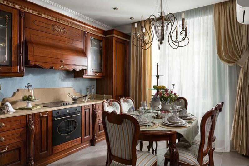 Oval wooden table in the interior of a classic kitchen