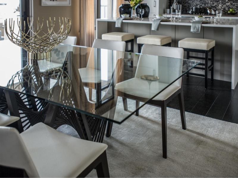 Glass table in the interior of the kitchen combined with the dining room and living room