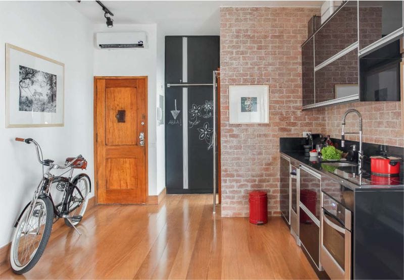 Black kitchen with brick wall