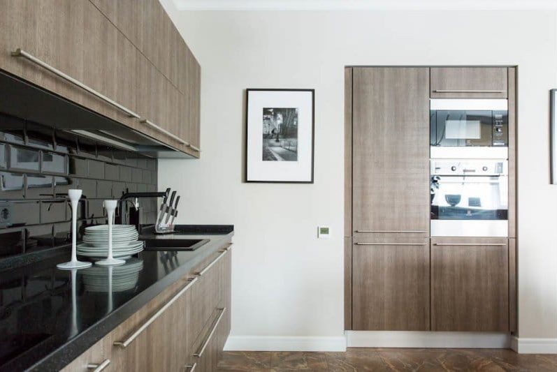 Black color and light wood in the interior of the kitchen