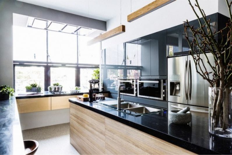 Black color and light wood in the interior of the kitchen