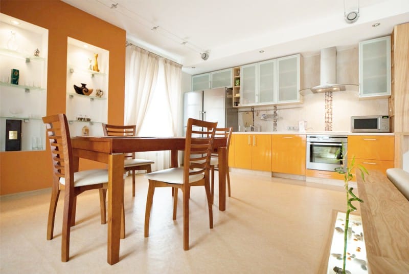 Accent wall of orange color in the kitchen interior