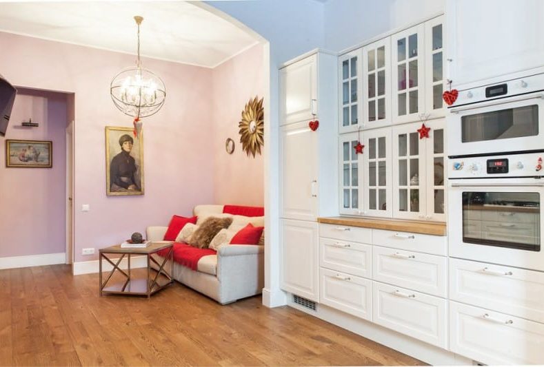 Lilac-pink walls in the interior of the kitchen-living room with insufficient lighting