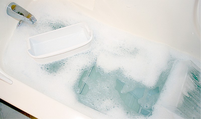 Soaking the removable parts of the refrigerator in the bath