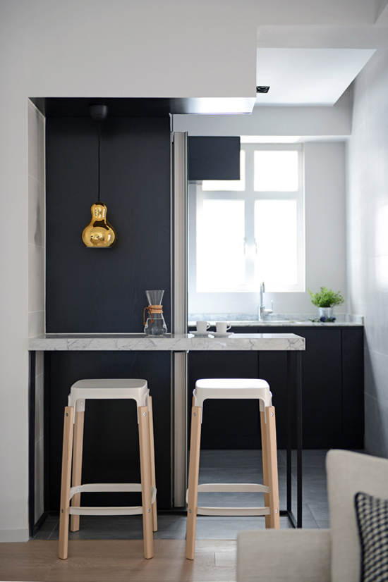 Golden lamp in black and white kitchen