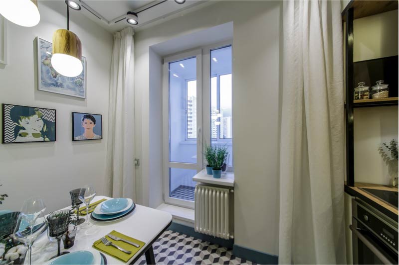 Interior of modern kitchen with balcony and white curtains