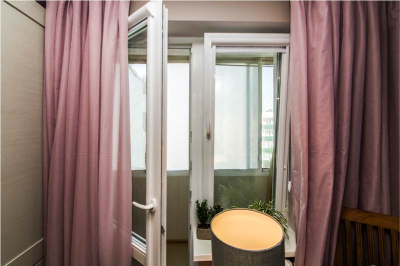 Window decoration with a balcony door, roller blinds and curtains